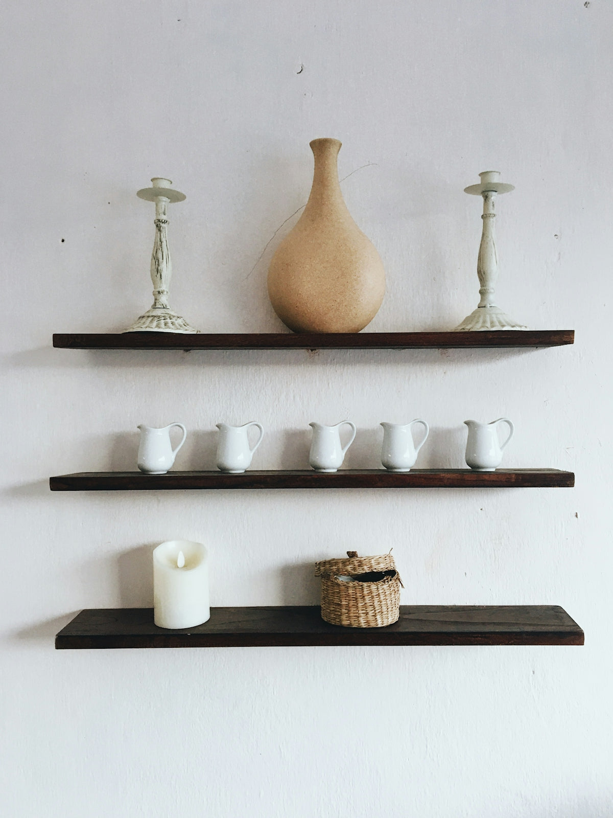 white and brown ceramic vase on white wooden shelf