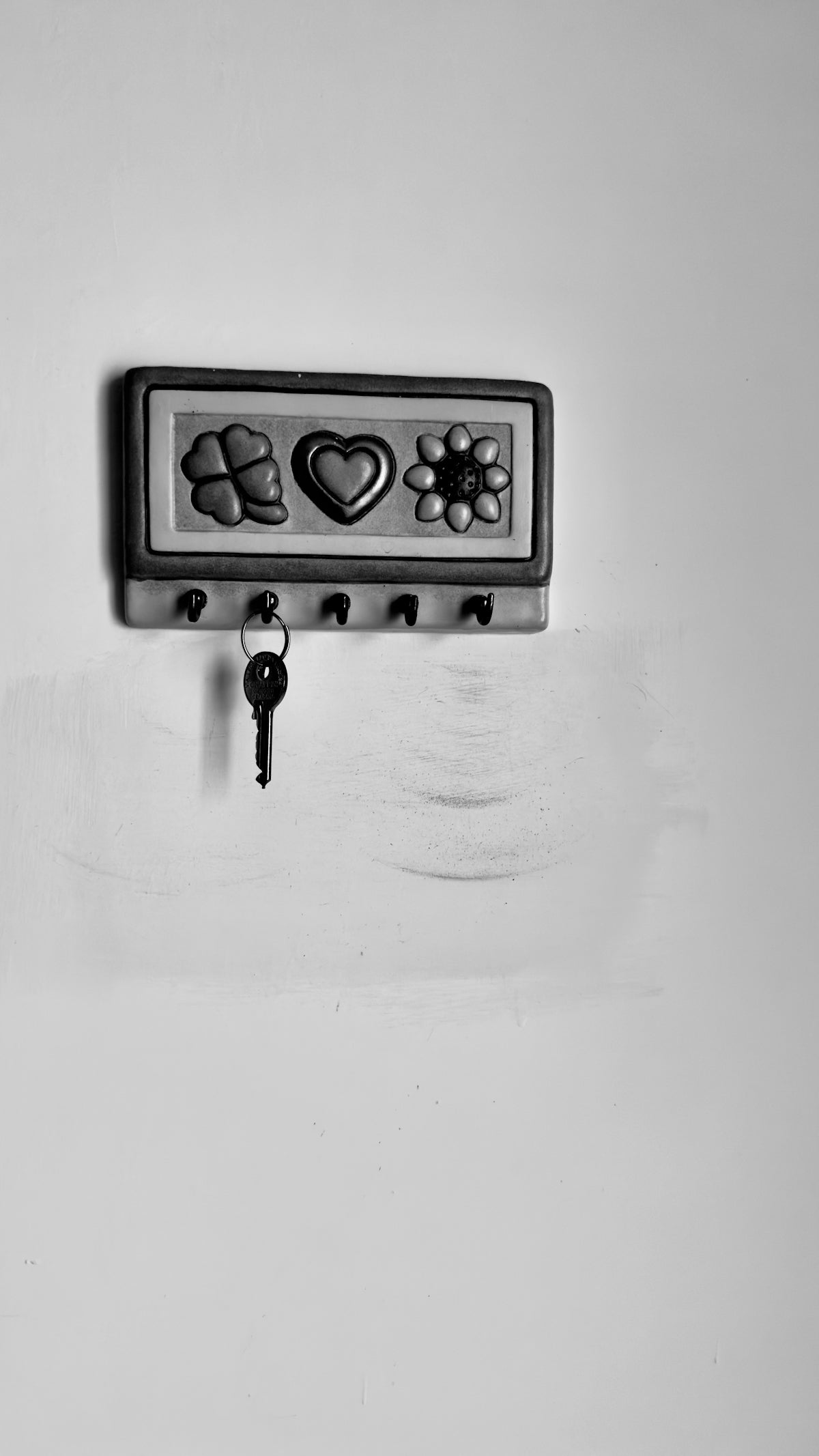 A black and white photo of a key on a wall